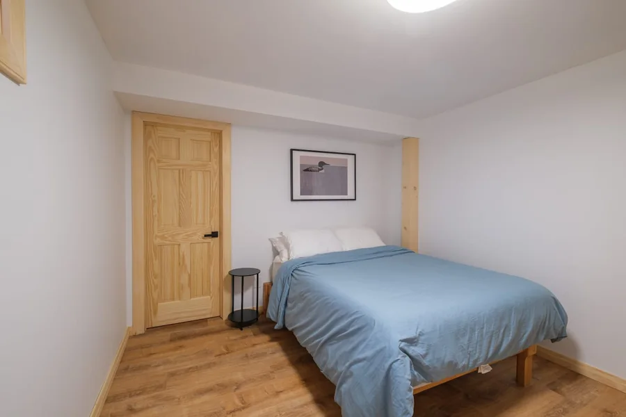 Lower-level bedroom with a queen bed and blue bedding